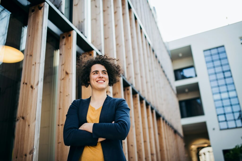 A happy young business woman standing outdoors, resting